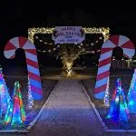 Magically lit Christmas trees and giant candy canes at the entrance to Holiday Magic