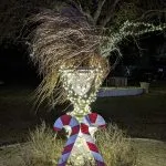 An urn is decorated with lights and candy canes