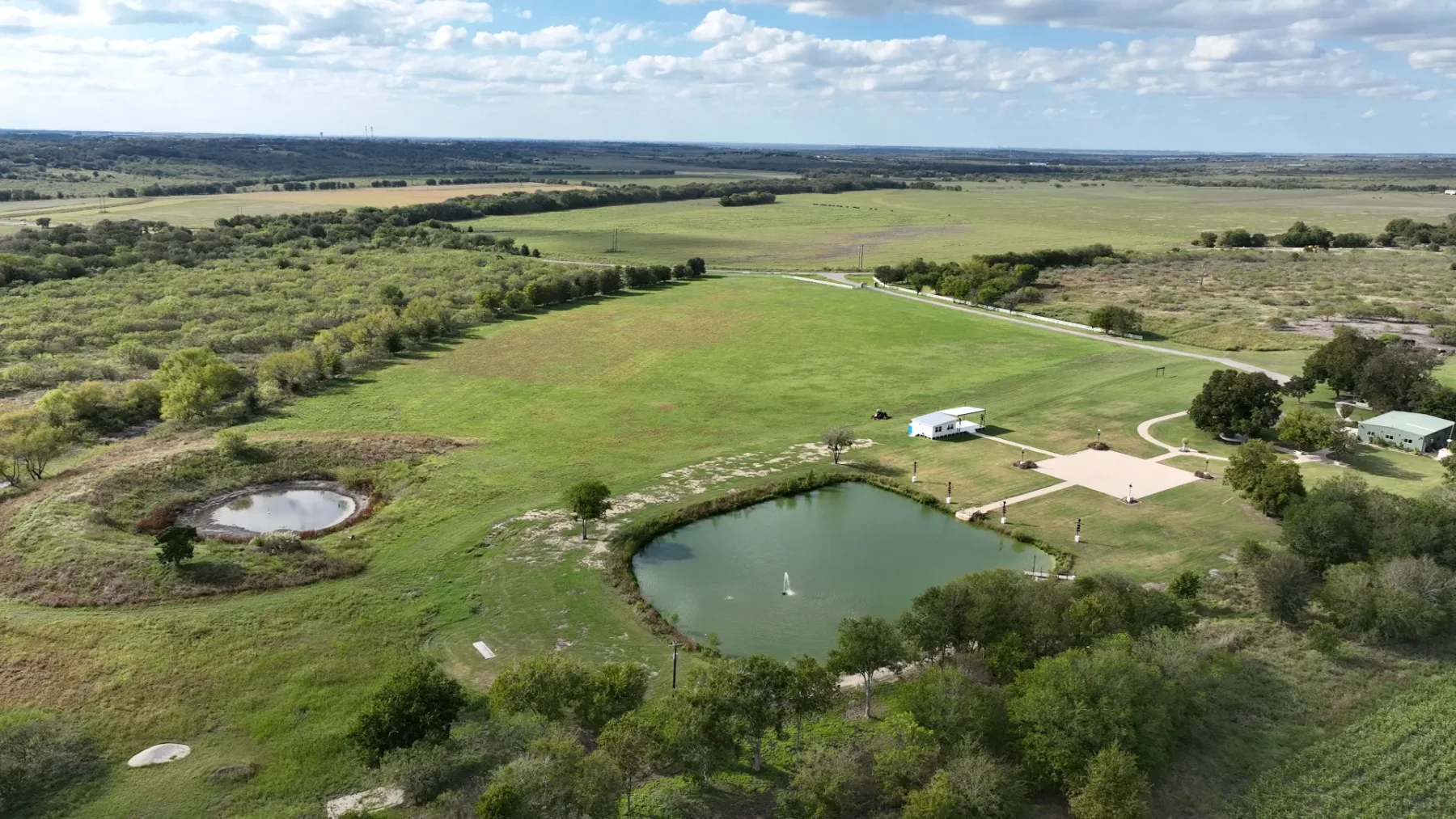 An aerial view of the pond, event square, stages, and surrounding grounds
